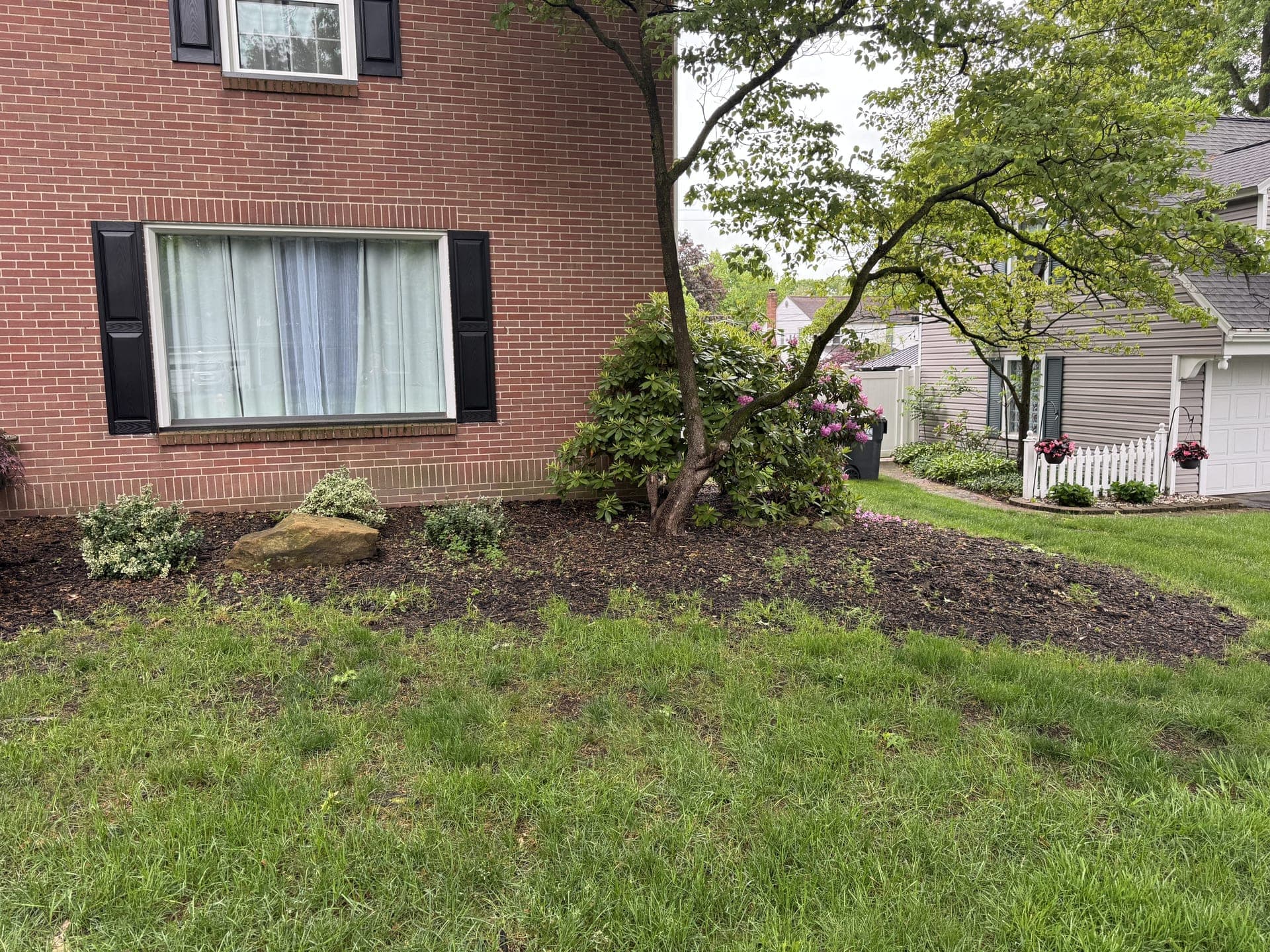 Front yard beds with faded mulch before landscaping service